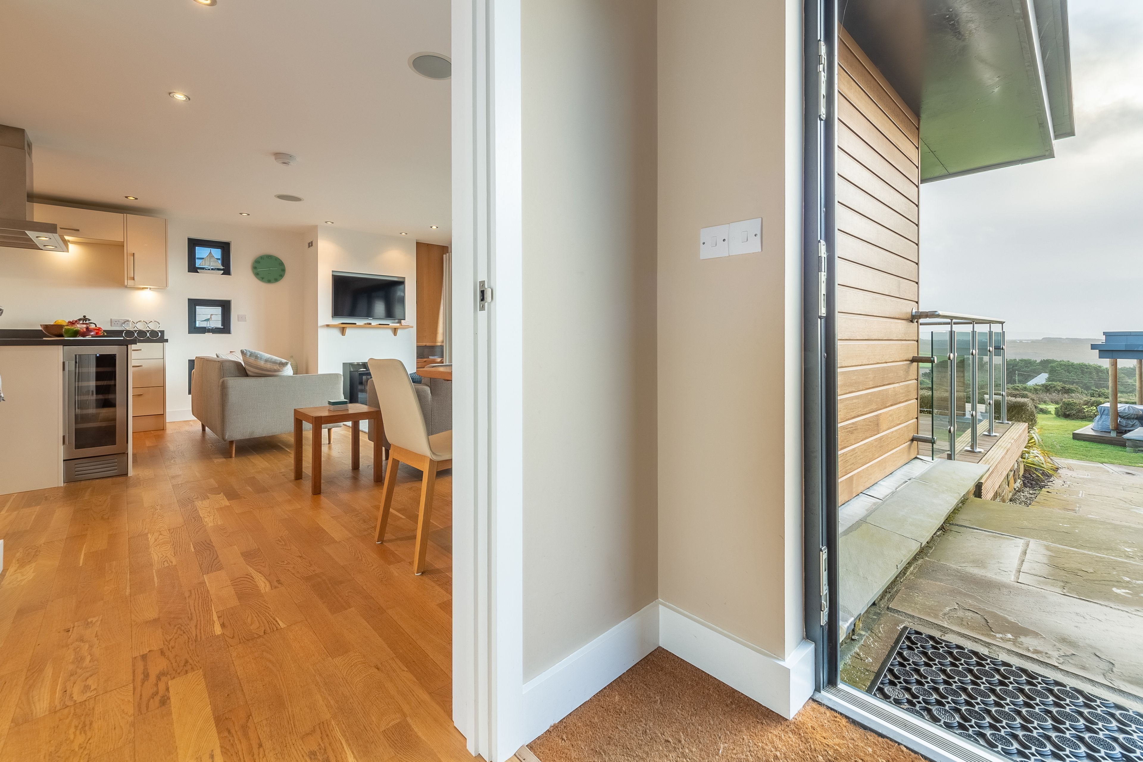 A modern interior with a kitchen, dining area, and a balcony with a view.