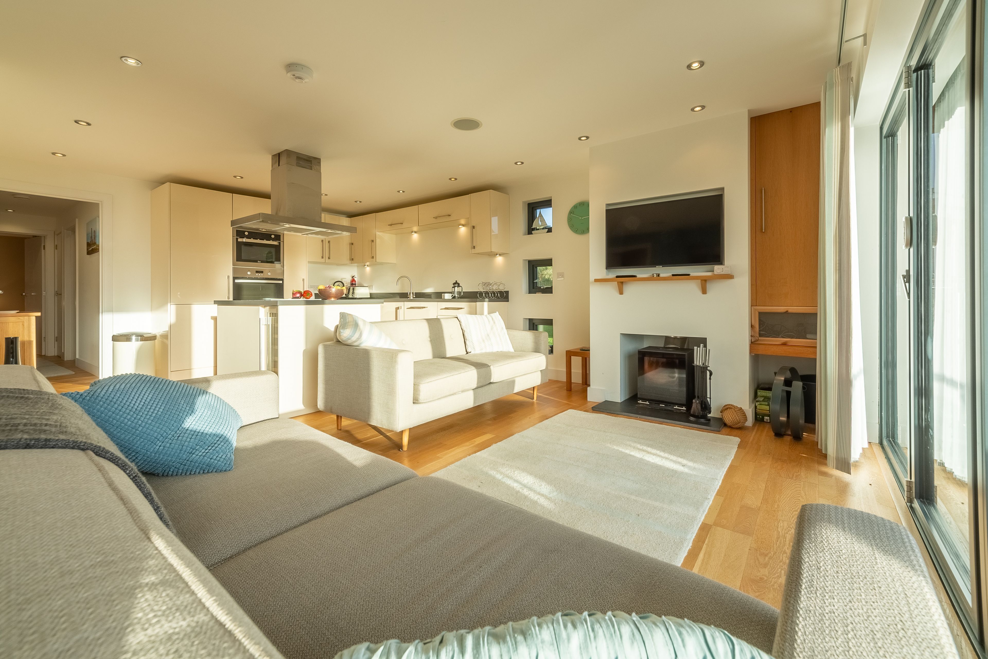 A modern living room with a sofa, a television, and a fireplace.