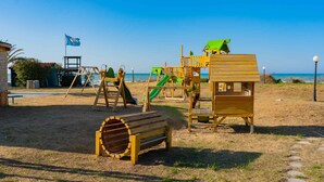 A beach playground with a slide, climbing structures, and a lookout tower.