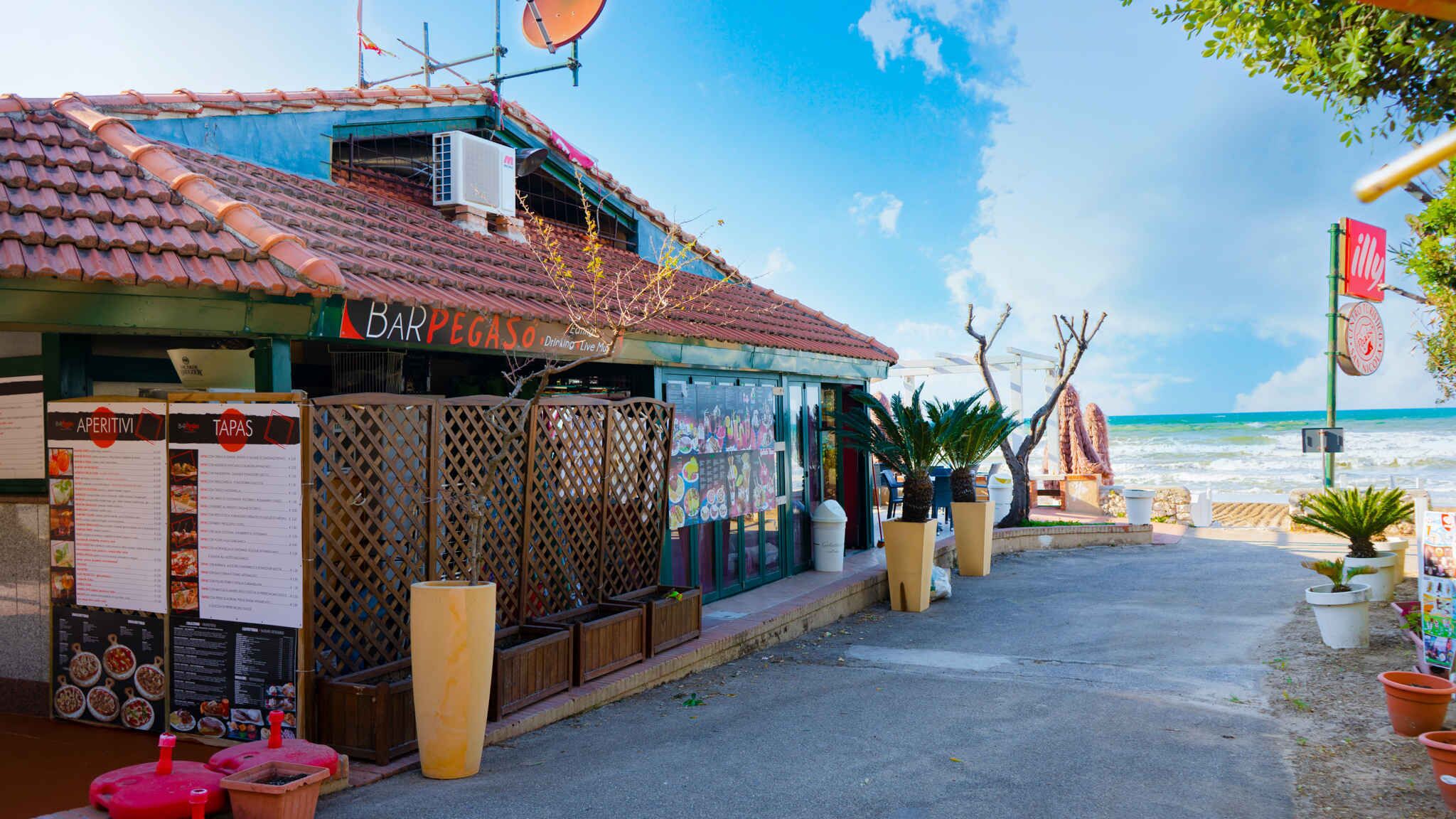 Un restaurante frente al mar con terraza, un menú y vistas al océano.