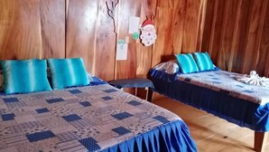 Une chambre avec deux lits, chacun recouvert d’une courtepointe bleue et agrémenté d’oreillers assortis.