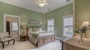 A bedroom with a bed, a chair, a desk, and a window. - Charming Southern Bungalow Convenient to Savannah (Bloomingdale)