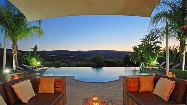 An outdoor seating area with a pool, wooden furniture, and a view of the landscape. - Skouli: A traditional property in Skoulli, near Polis, with heated pool (Polis)