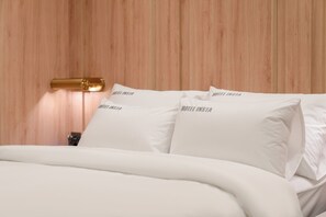 A hotel room with a wooden headboard, white bedding, and pillows with the hotel's name. - Hotel INSTA Suwon City Hall (Suwon)