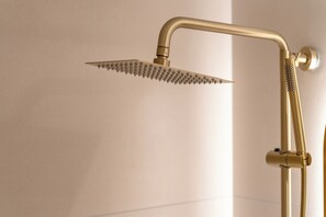 A gold-colored showerhead with a curved design and a handheld shower attachment. - Hotel INSTA Suwon City Hall (Suwon)