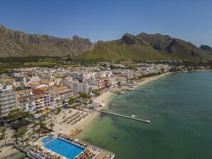 Un pueblo costero con playa, muelle y piscina.