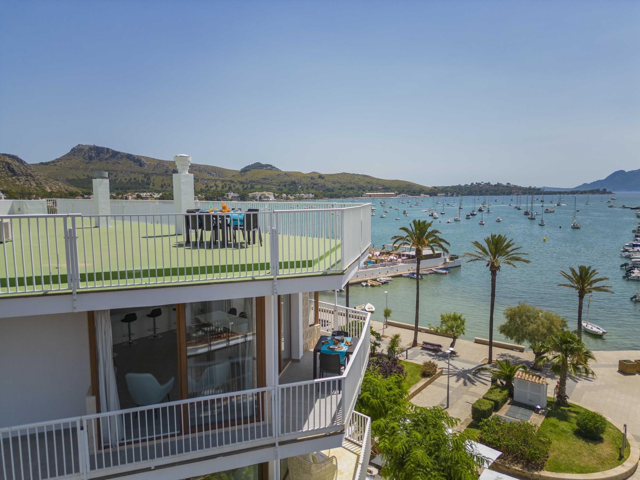 A multi-level balcony with outdoor seating overlooking a marina with boats.