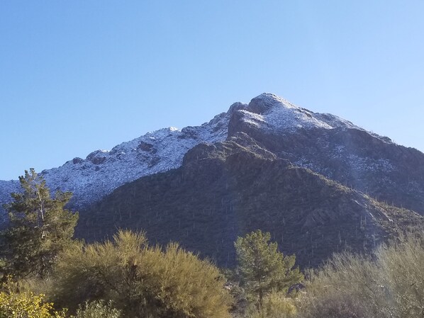 Una montaña con picos nevados y un cielo azul despejado.