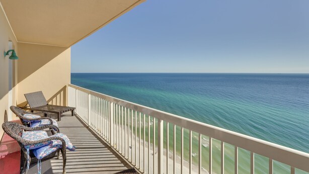 A balcony with wicker chairs and a table, overlooking a beach and the ocean. - Gulf Coast Getaway w/ Balcony & Resort Amenities! (Panama City Beach)