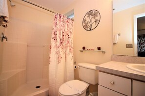 Ein Badezimmer mit Dusche, Toilette und Waschbecken.