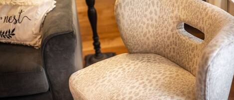 A room with a grey sofa and a patterned armchair.