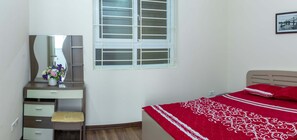 Cozy retreat with a comfortable bed, nightstand, and mirror, set against a clean, minimalist backdrop.