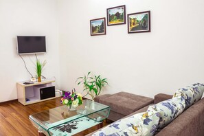 Relax in this stylish living room with a flat-screen TV, comfortable sofa, and a glass coffee table.