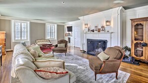 A spacious living room with a fireplace, a large sofa, and several armchairs. - Spacious Estate w/ Courtyard: 2 Miles to Downtown! (Keene)