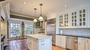 A spacious kitchen with white cabinetry, a large island, and a tiled floor. - Spacious Estate w/ Courtyard: 2 Miles to Downtown! (Keene)