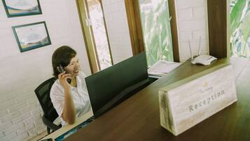 A reception desk with a sign labeled "Reception" and a laptop on the desk.