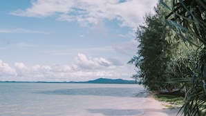 A beach with clear water, a sandy shore, and some greenery. - The Kelong Trikora Resort (Bintan)