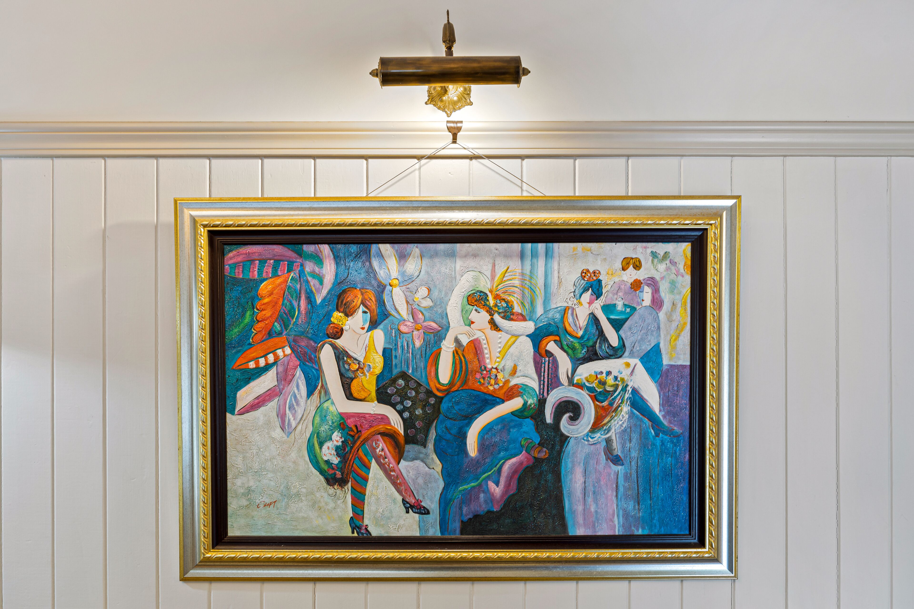 A framed painting of four women in colorful attire.