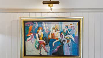 A framed painting of four women in colorful attire.