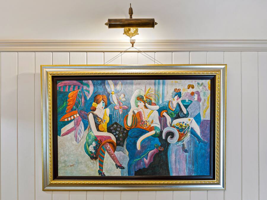 A framed painting of four women in colorful attire.