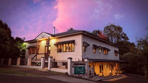 A two-story building with a sign reading "The Guesthouse 1334" at the entrance. - The Guesthouse (Maleny)