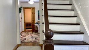 A staircase with a wooden handrail and a doormat with children's names. - Hunter Mountain Getaway House, newly renovated (Hunter)
