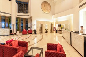 A spacious lobby with a reception desk, red seating, and a large decorative wall. - Sunday Hotel Jaipur (Jaipur)