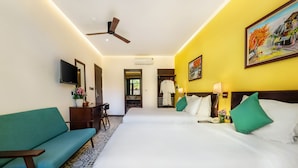 A hotel room with two beds, a sofa, a TV, and a ceiling fan. - Villa Soleil Hoi An (Da Nang)