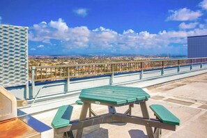 A picnic table with a view of a cityscape and a bridge.