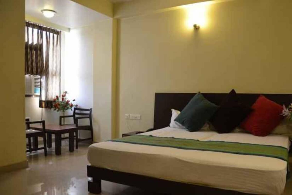 A hotel room with a bed, a desk, and chairs.