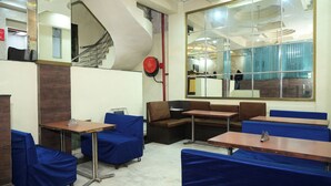 A hotel lobby with a staircase, seating areas, and a large window. - Hotel Ankur Palace (Jaipur)