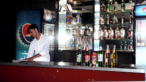 A bar area with a variety of liquor bottles and a Pepsi refrigerator. - Hotel Ankur Palace (Jaipur)