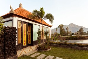 A traditional building with a tiled roof, a stone wall, and a glass door.
