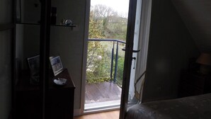 A room with a balcony, a desk with a picture frame, and a bed. - Independent dwelling in 1 detached house near sea. (GUIDEL)