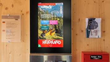 A digital display with a welcome message, a red badge box, and a payment terminal.