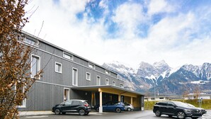 A modern building with a covered parking area and a mountain backdrop. - Cubilaris Motel Bad Ragaz (Bad Ragaz)