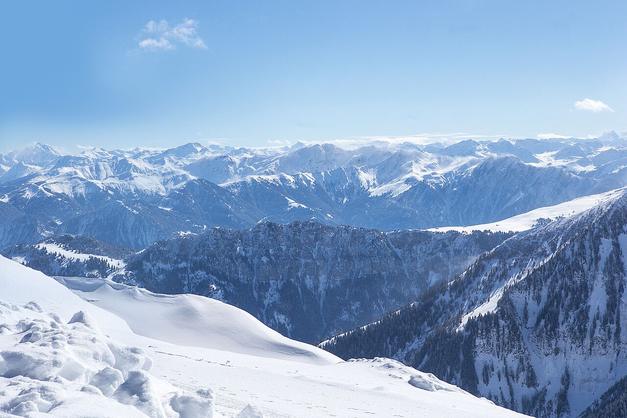 Una vista panorámica de montañas nevadas con cielos despejados.