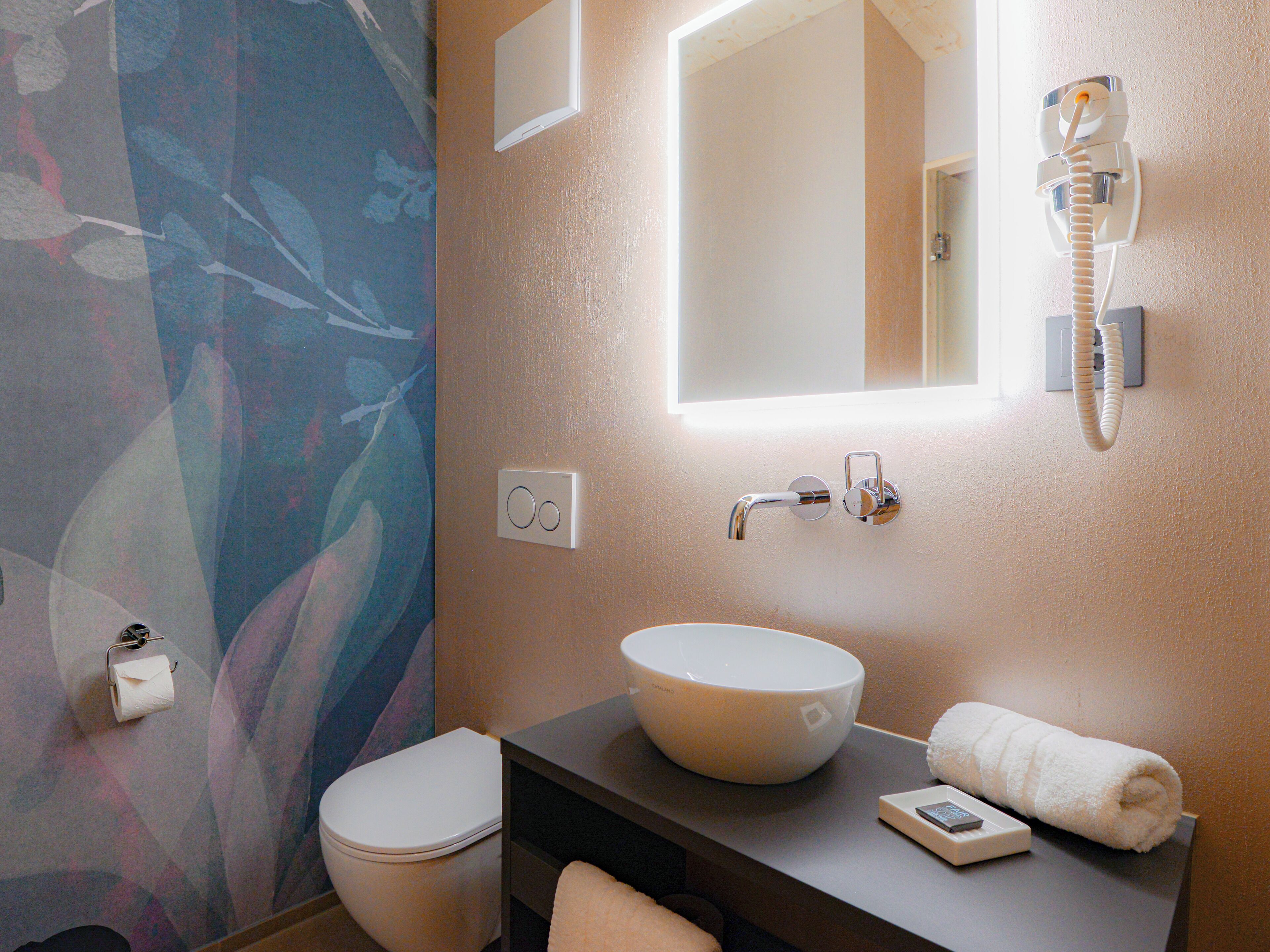 Ein Badezimmer mit Toilette, Waschbecken und Spiegel.