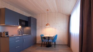 A compact kitchen with grey cabinets, a stainless steel sink, and a pendant light. - Cubilaris Motel Bad Ragaz (Bad Ragaz)
