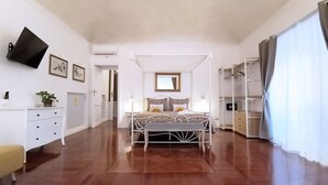 A bedroom with a four-poster bed, a white dresser, a bedside table, a TV mounted on the wall, and a walk-in closet. - ♡♡♡ Norma ♡♡♡ (Roma)