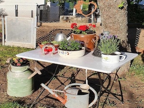 A garden table with potted plants and gardening tools.