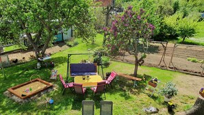 A backyard with a swing set, a table with chairs, a sandbox, and a small garden area. - Apartment on Staufenberg (Blankenburg (Harz))
