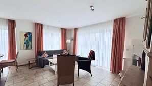 Una sala de estar con sofá, sillones, una mesa de centro y una chimenea.