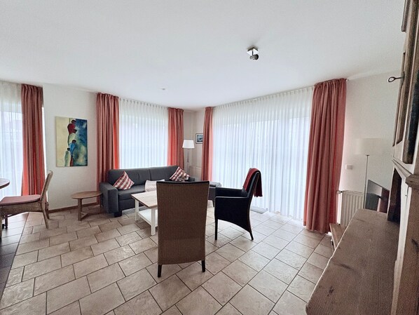 Un salon comprenant un canapé, des fauteuils, une table basse et une cheminée.