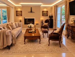 A spacious living room with a large sofa, a coffee table, and a fireplace.