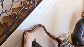 A staircase with ornate black metal railings and wooden steps. - Homerez - Villa in Ribérac (Ribérac)