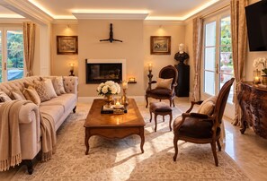 Un salon élégant, doté d’un canapé, de fauteuils, d’une table basse et d’une cheminée.
