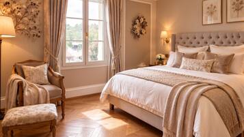 A bedroom with a large bed, a chair, a desk, and a window with curtains.