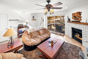 A living room with a sofa, coffee table, and fireplace. - Beautiful Townhouse! Walking Distance to Bear Mtn and Golf Course! Walk to Hiking! (Big Bear Lake)