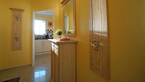 A kitchen with wooden cabinets, a countertop, and a mirror. - Dune Residence Bansin - Apartment B 03 (Heringsdorf)